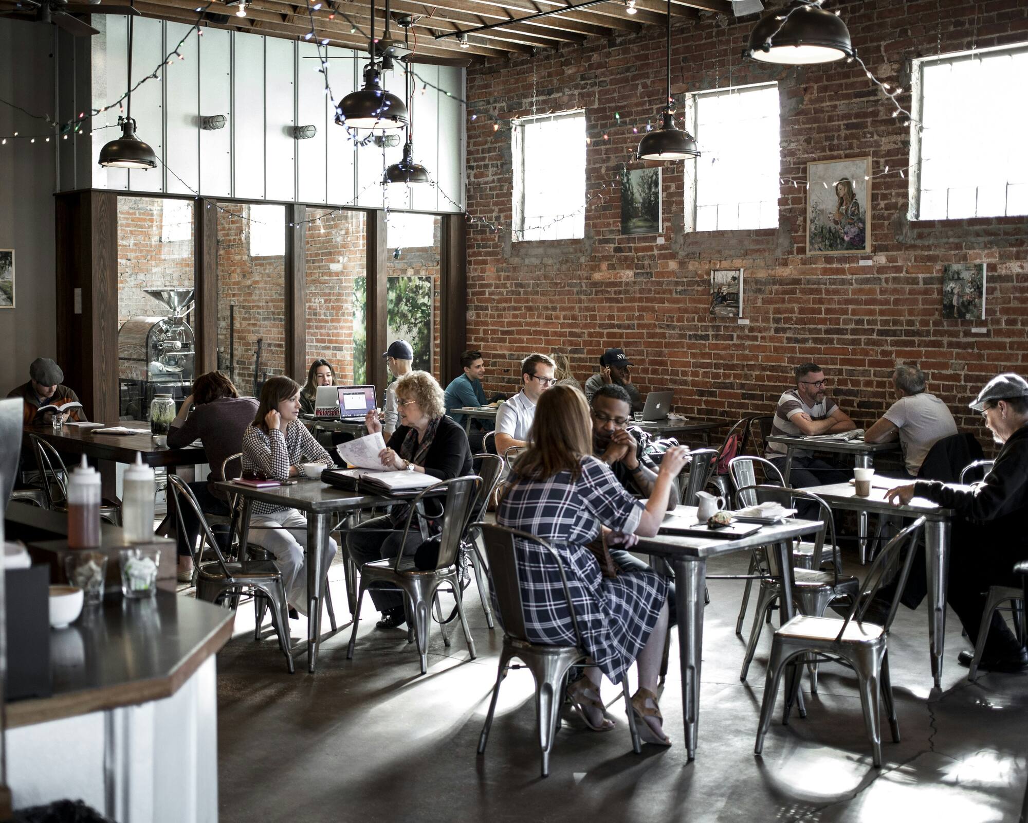 Tables of people working and talking in a busy coffee shop